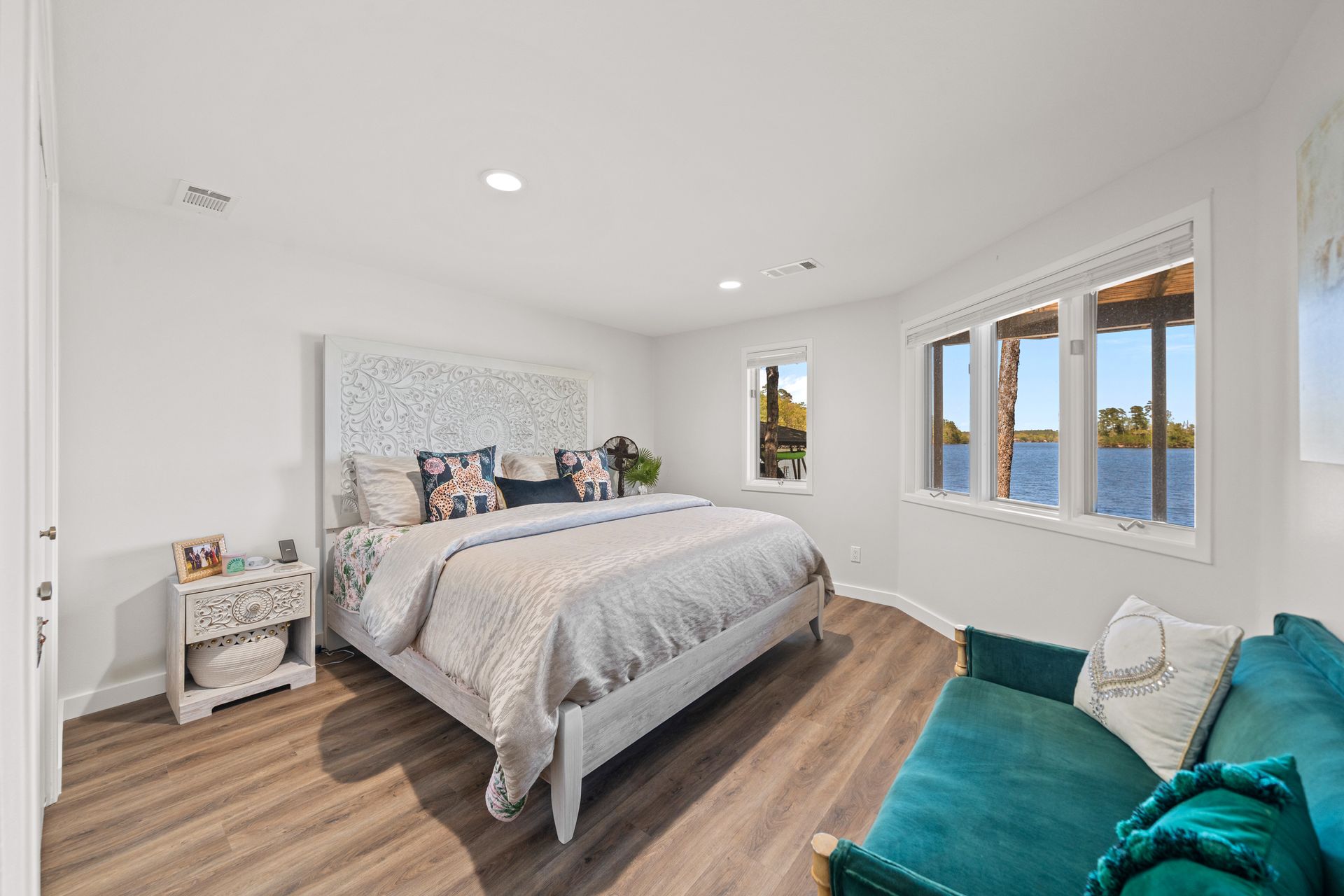 A bedroom with a king size bed , a couch , and a view of the water.