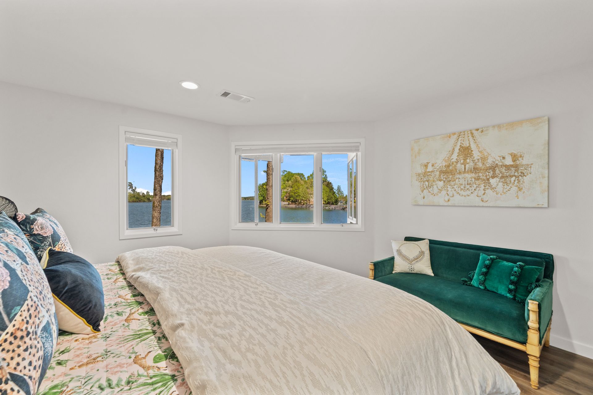 A bedroom with a large bed and a green couch.