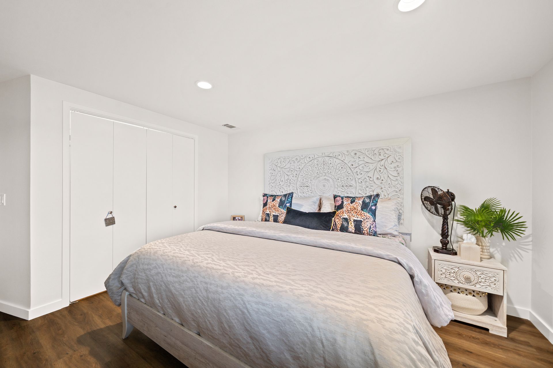 A bedroom with a king size bed , nightstand , and closet.