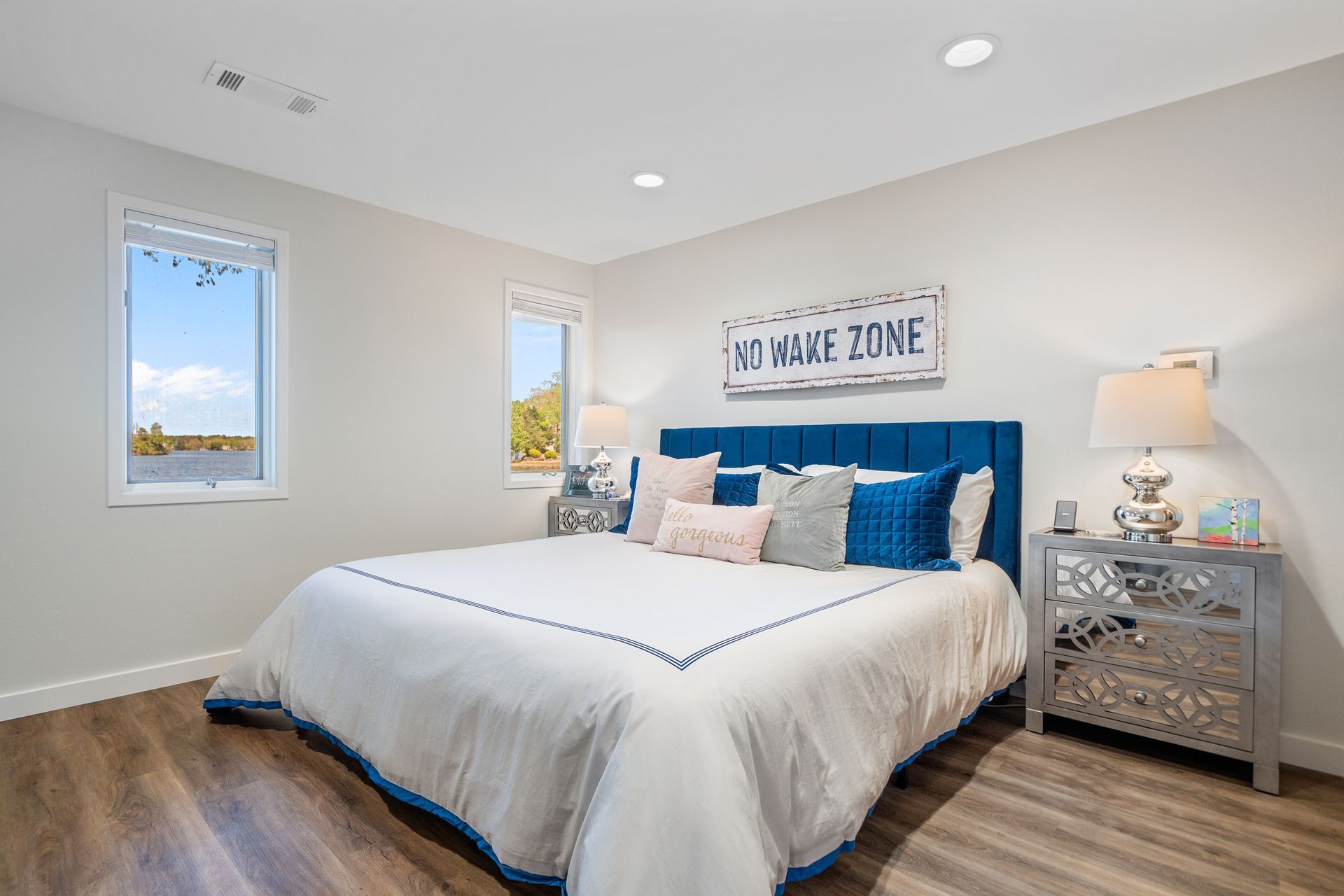 A bedroom with a large bed , nightstand , and window.