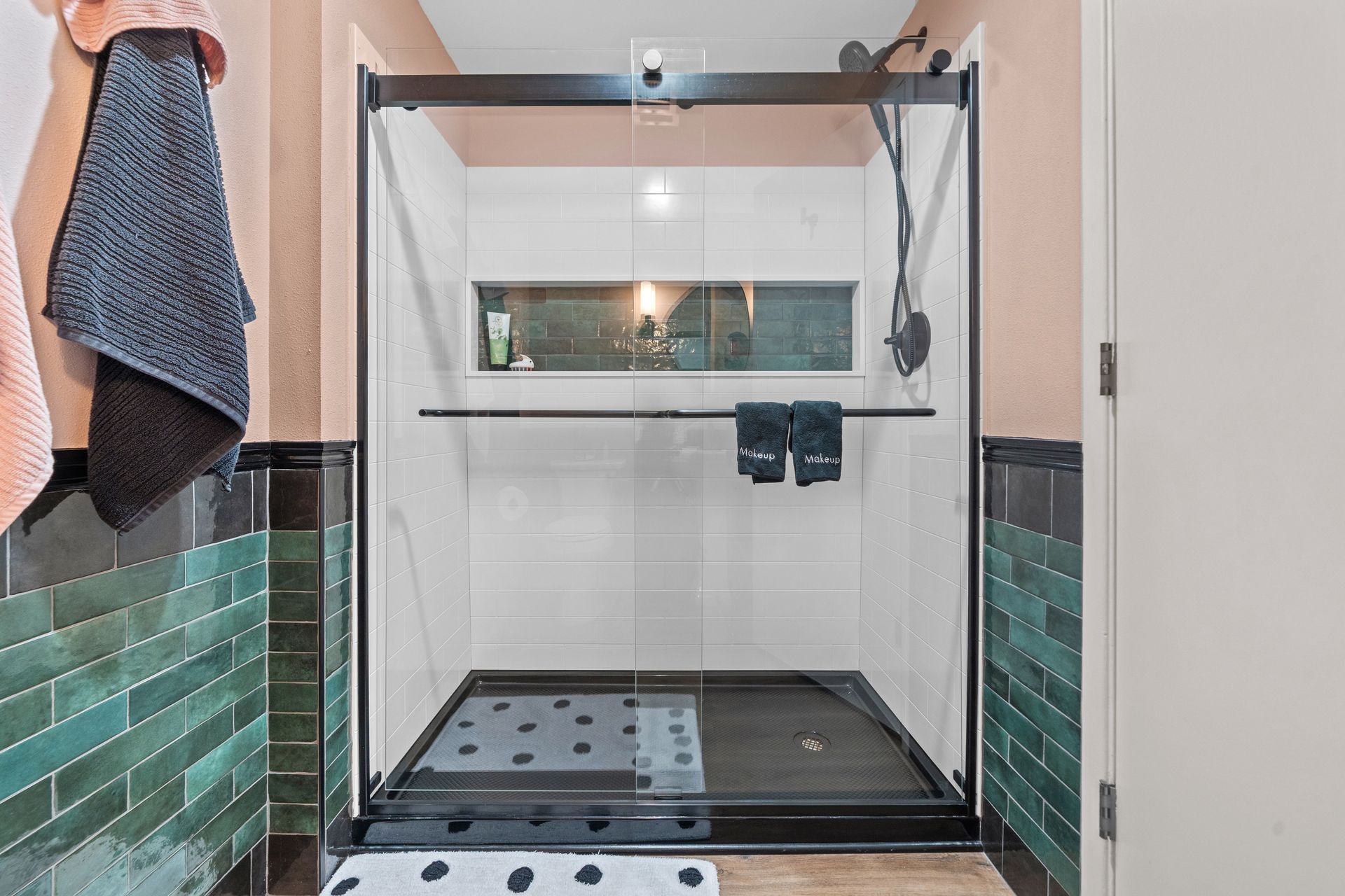 A bathroom with a walk in shower with a glass door.