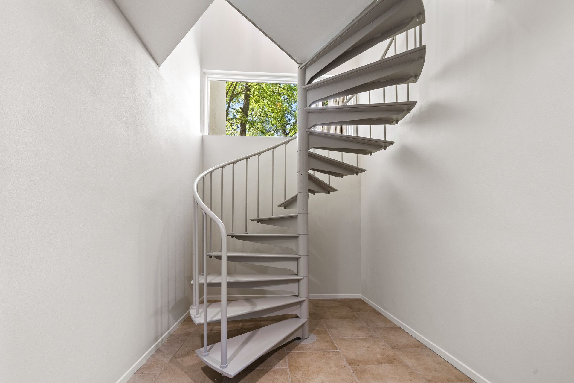 There is a spiral staircase in the middle of a room.