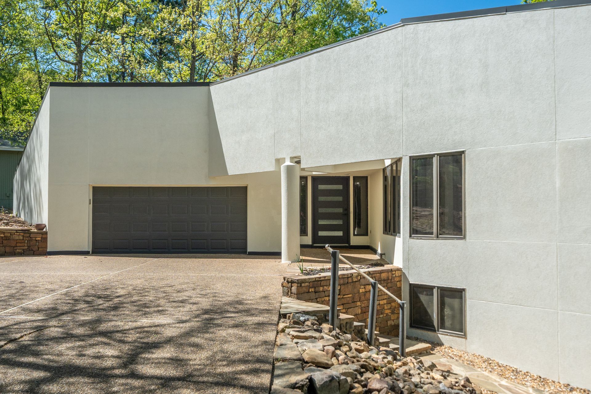 A large white house with a garage and stairs leading to it.