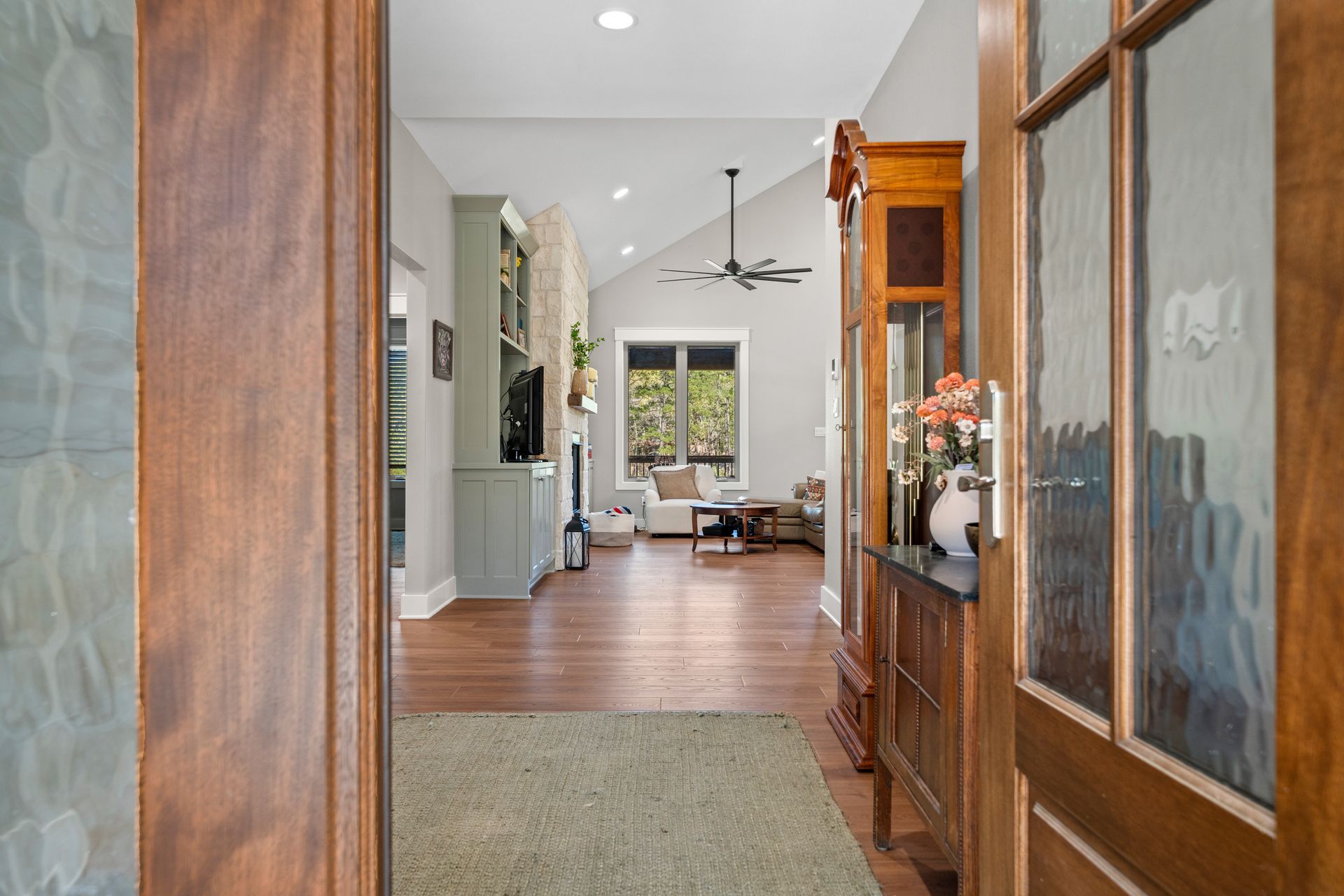 A view of a living room from the front door of a house.