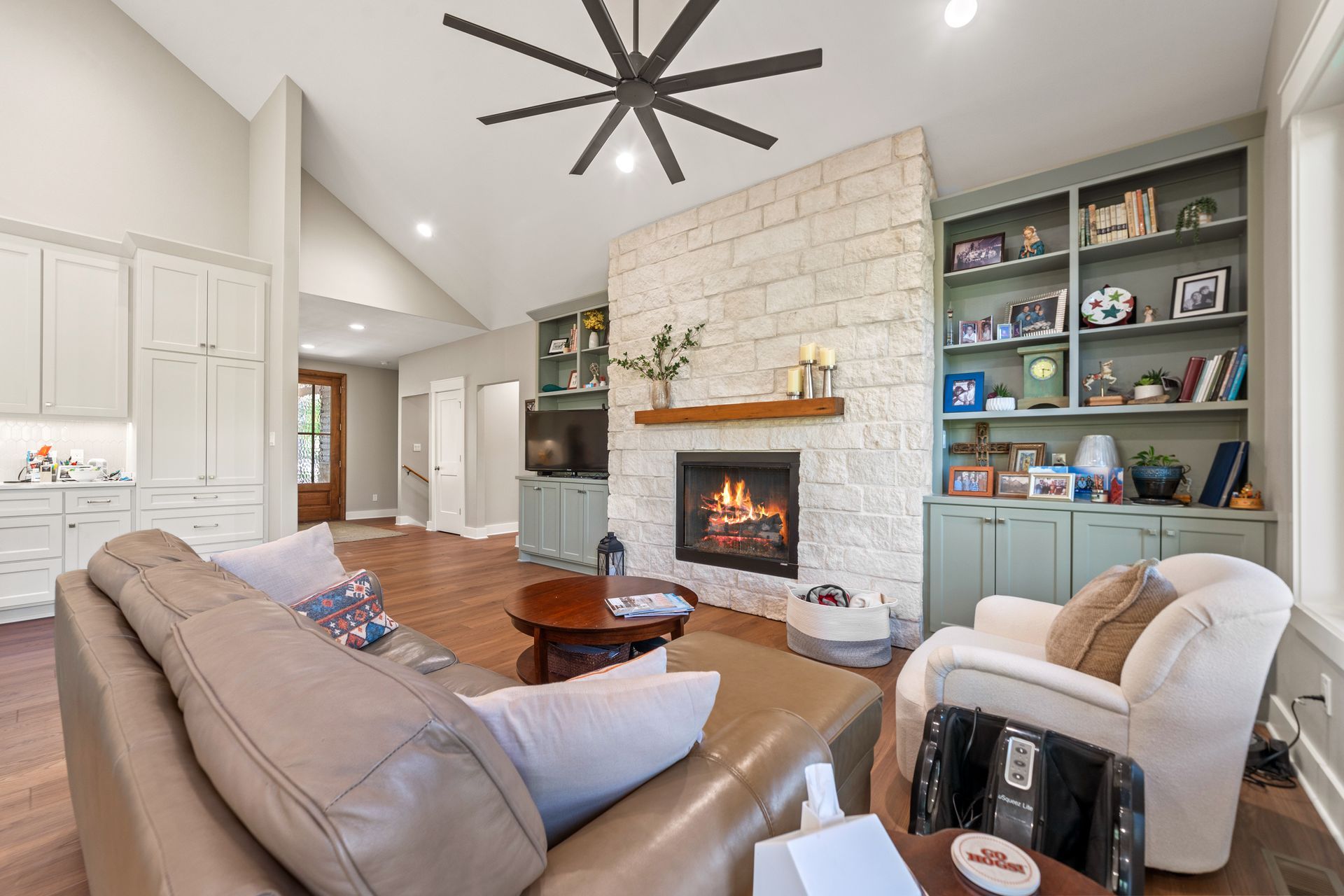 A living room with a fireplace and a ceiling fan.