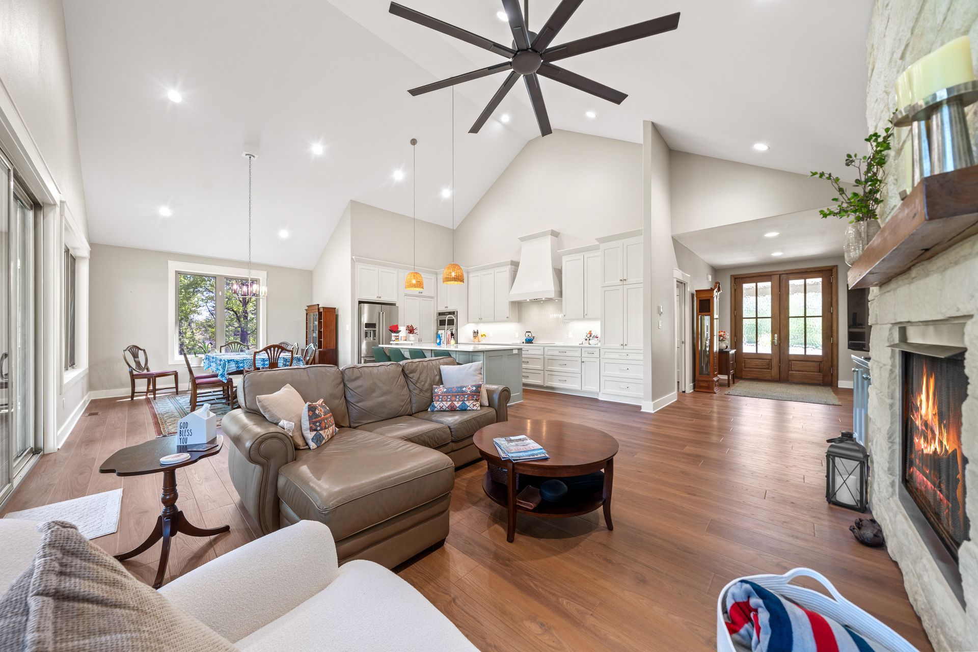 A living room filled with furniture and a fireplace with a ceiling fan.