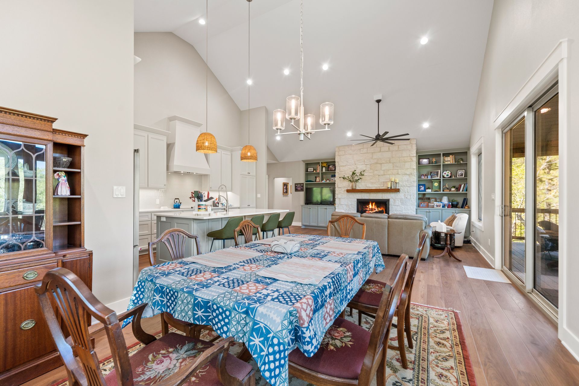 A dining room table with a blue tablecloth and chairs in a house.