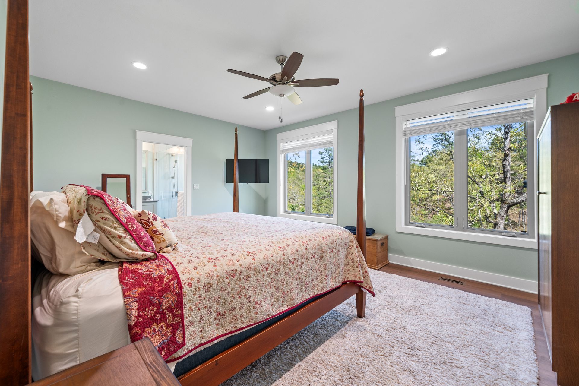 A bedroom with a four poster bed and a ceiling fan.