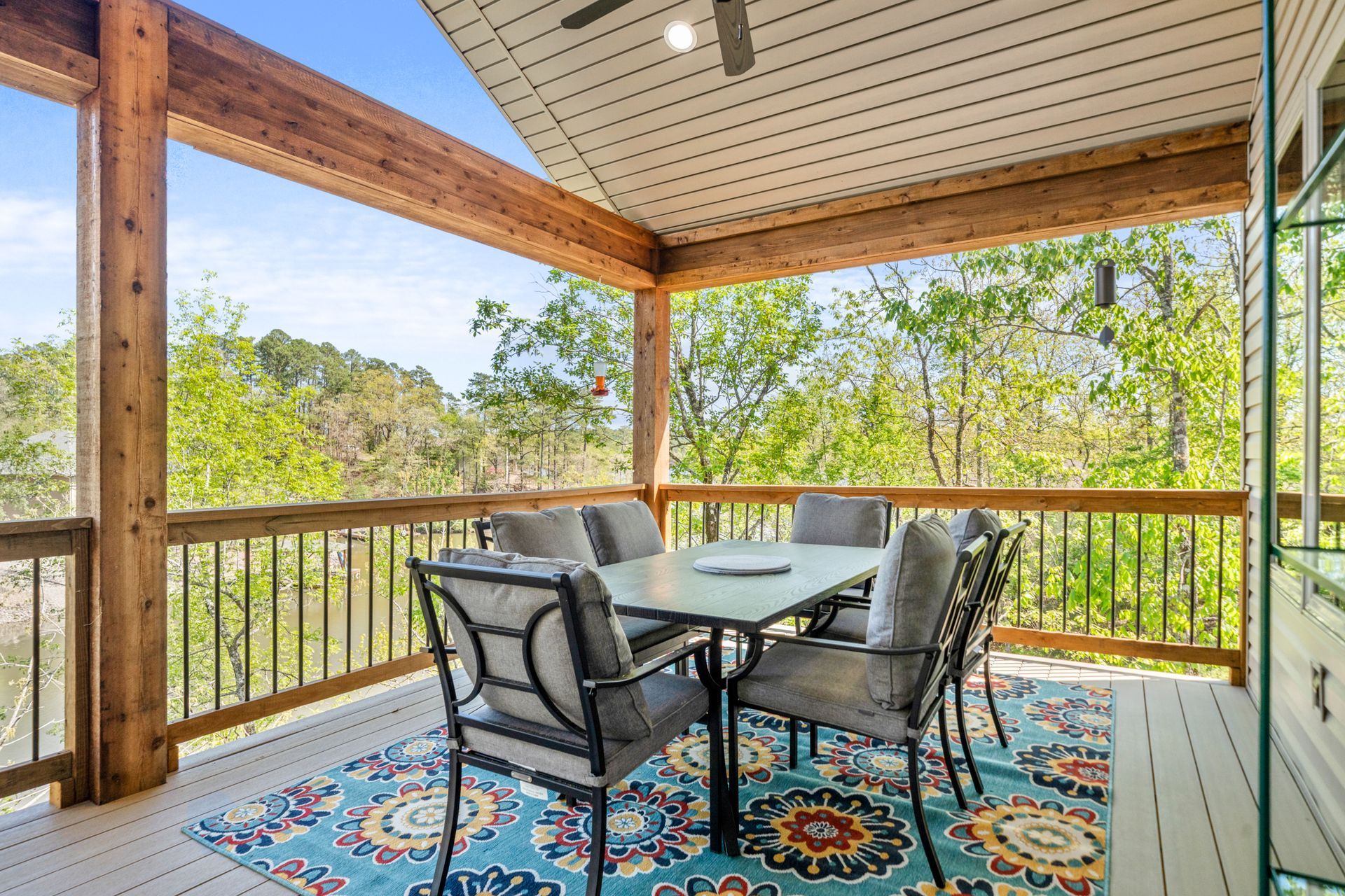 There is a table and chairs on the porch of a house.
