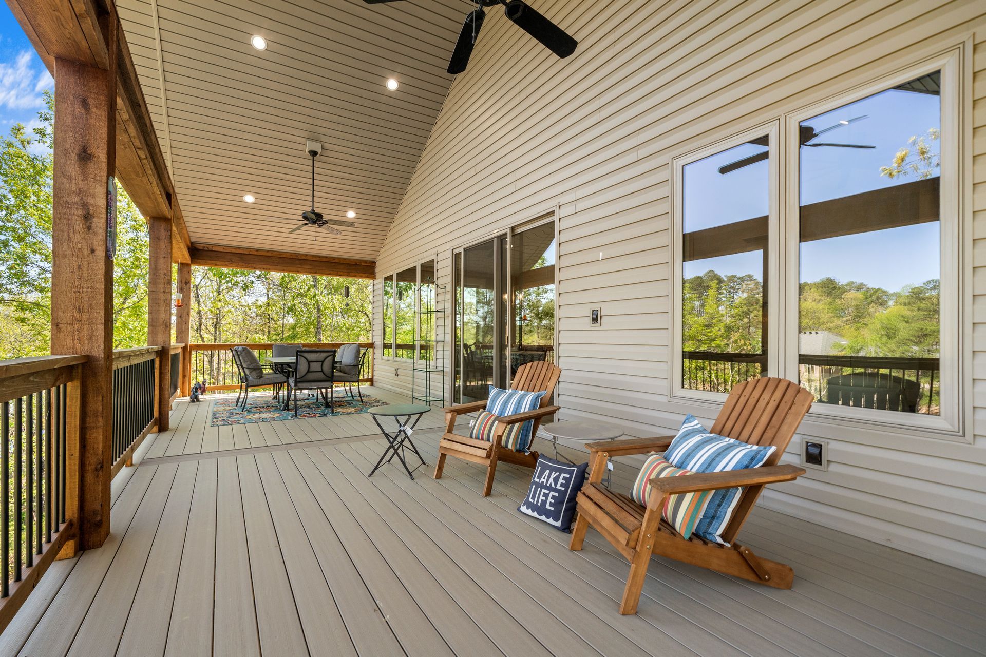 There are two chairs on the porch of a house.