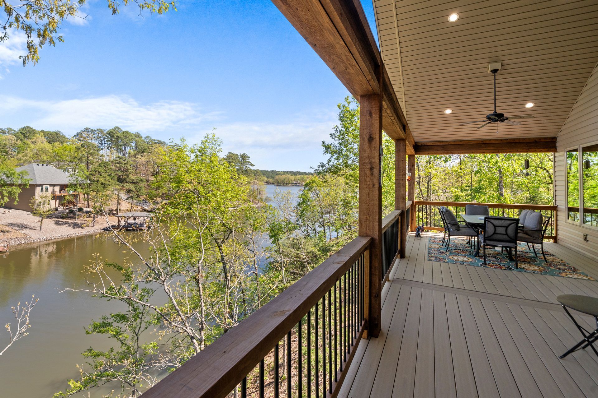 A large deck with a view of a lake and trees.