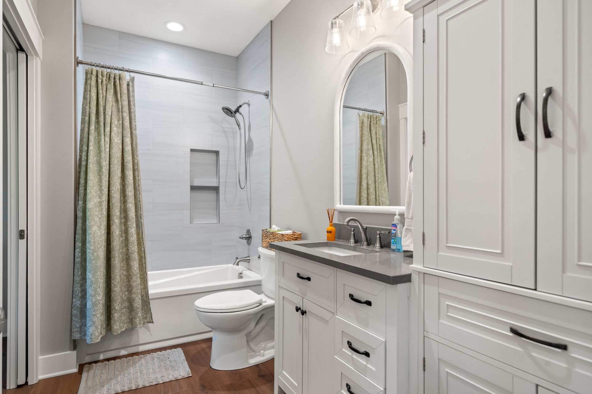 A bathroom with a sink , toilet , tub and mirror.