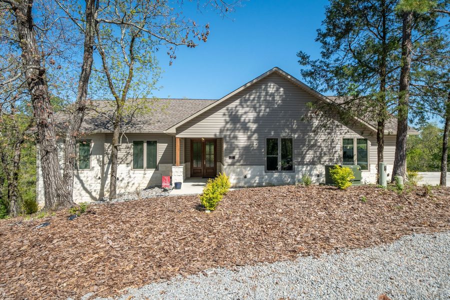 A house with a lot of leaves on the ground in front of it.