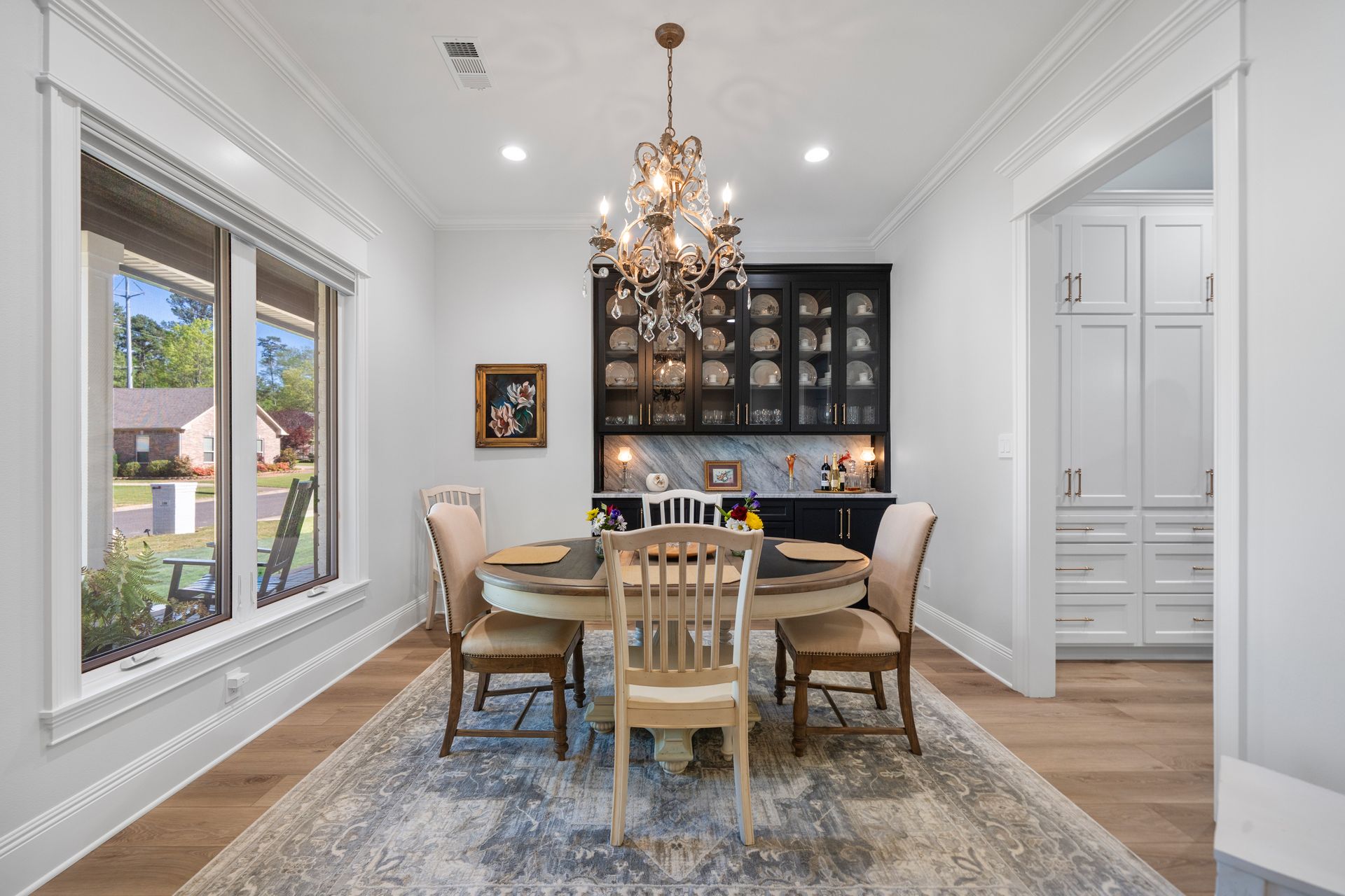 A dining room with a table and chairs and a chandelier.