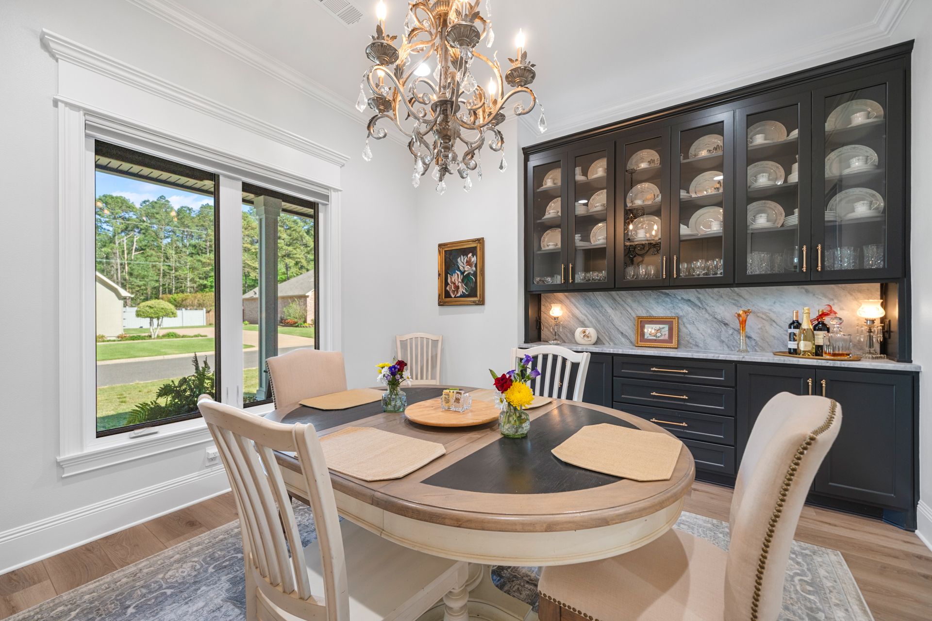 A dining room with a table and chairs and a chandelier.