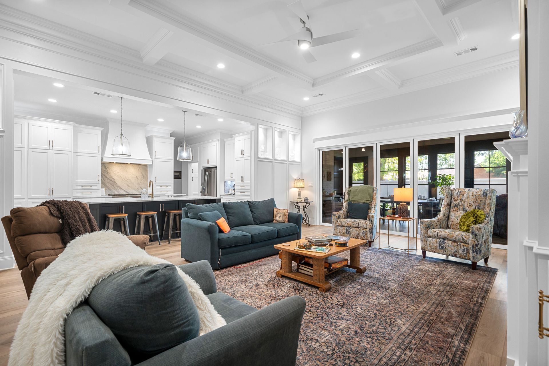 A living room with a couch , chairs , coffee table and rug.