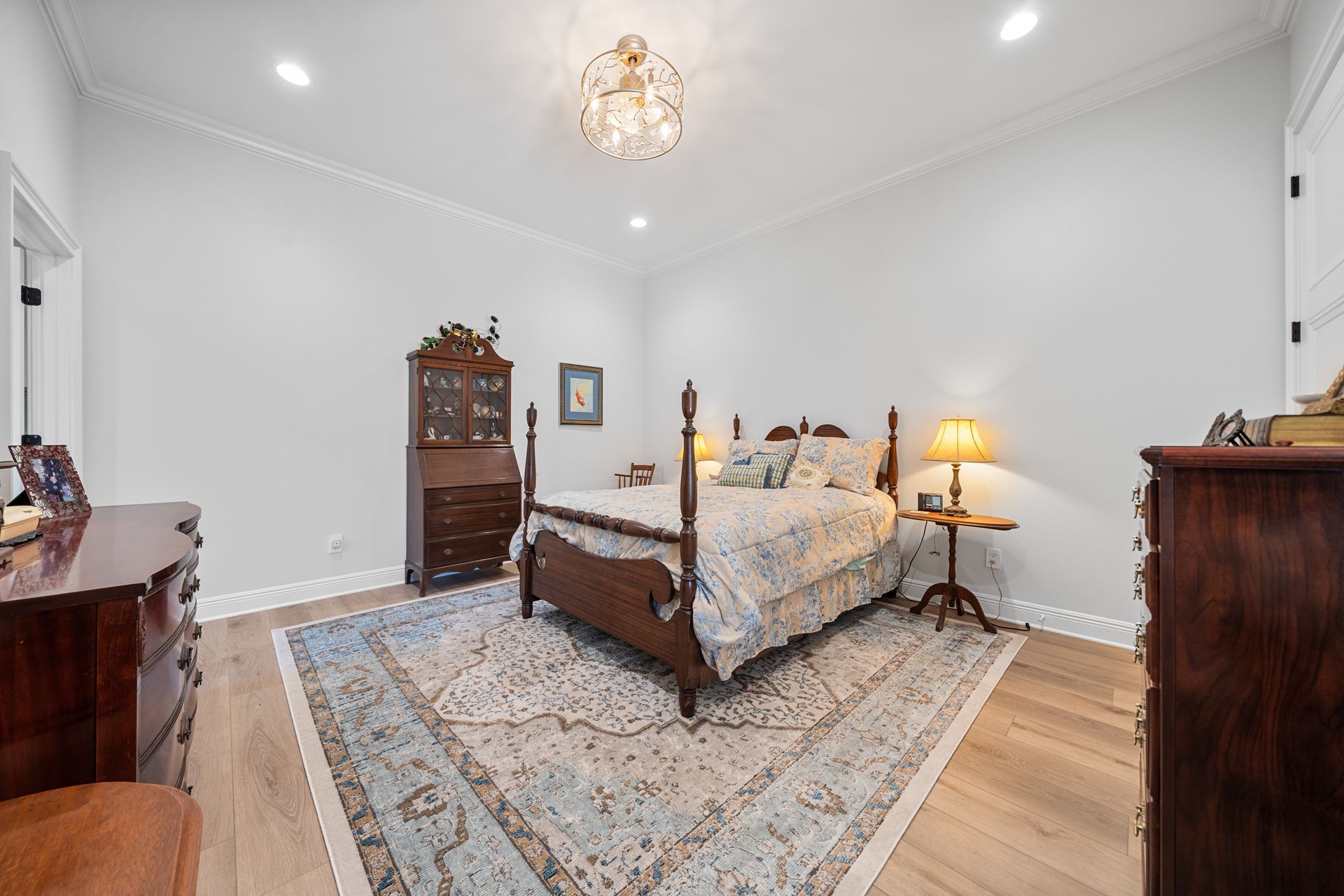 A bedroom with a bed , dresser , and rug.