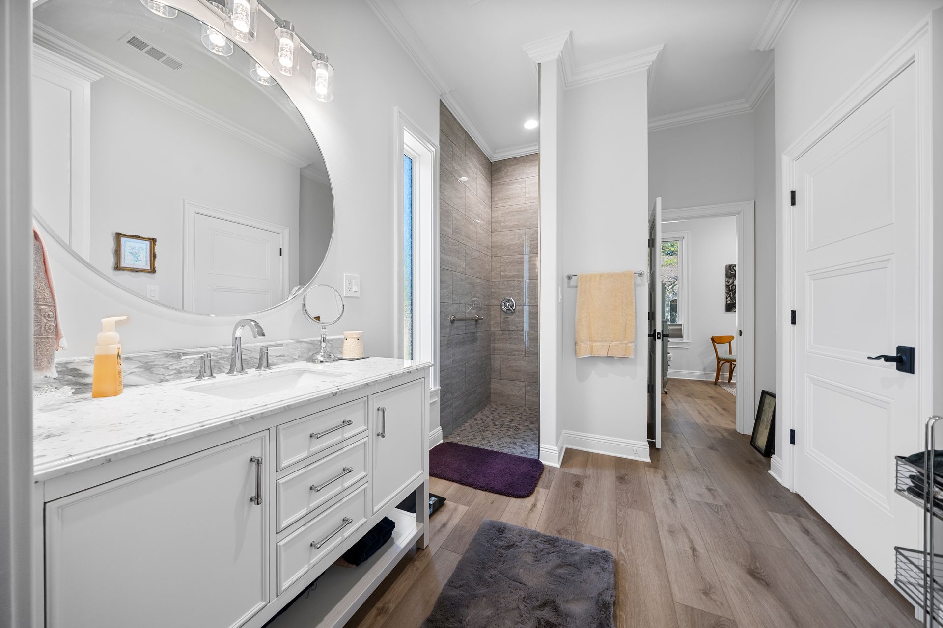 A bathroom with two sinks and a walk in shower.