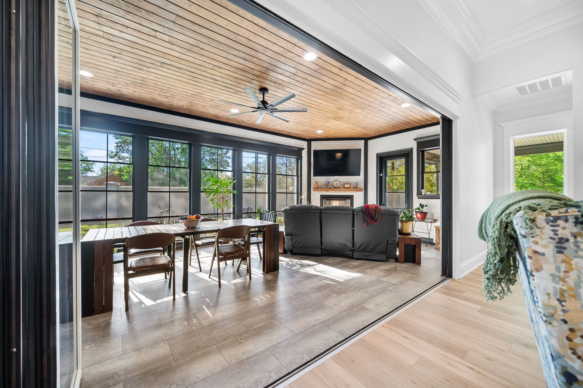 A living room with a table and chairs and a ceiling fan.
