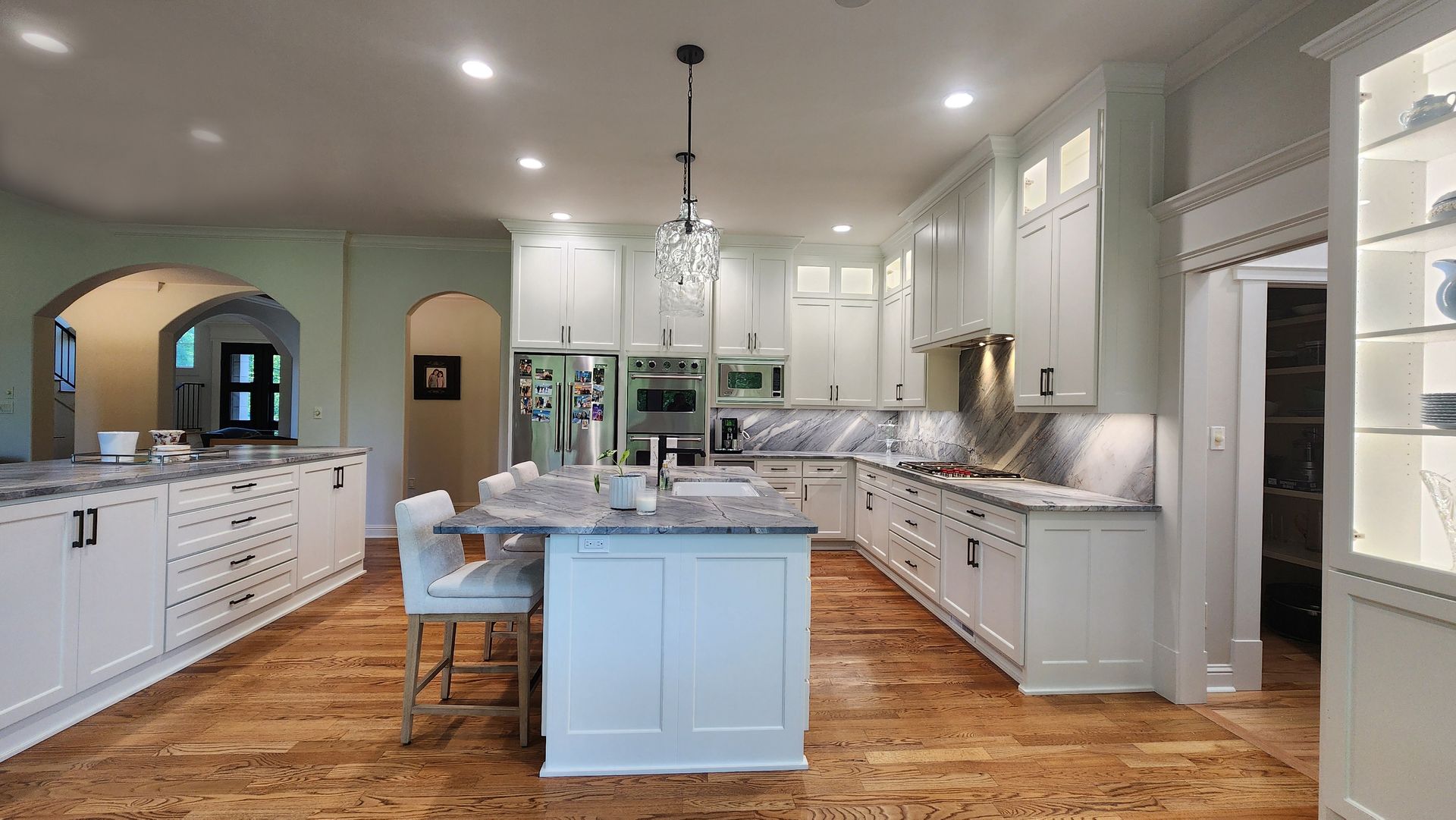 A large kitchen with white cabinets and a large island in the middle.