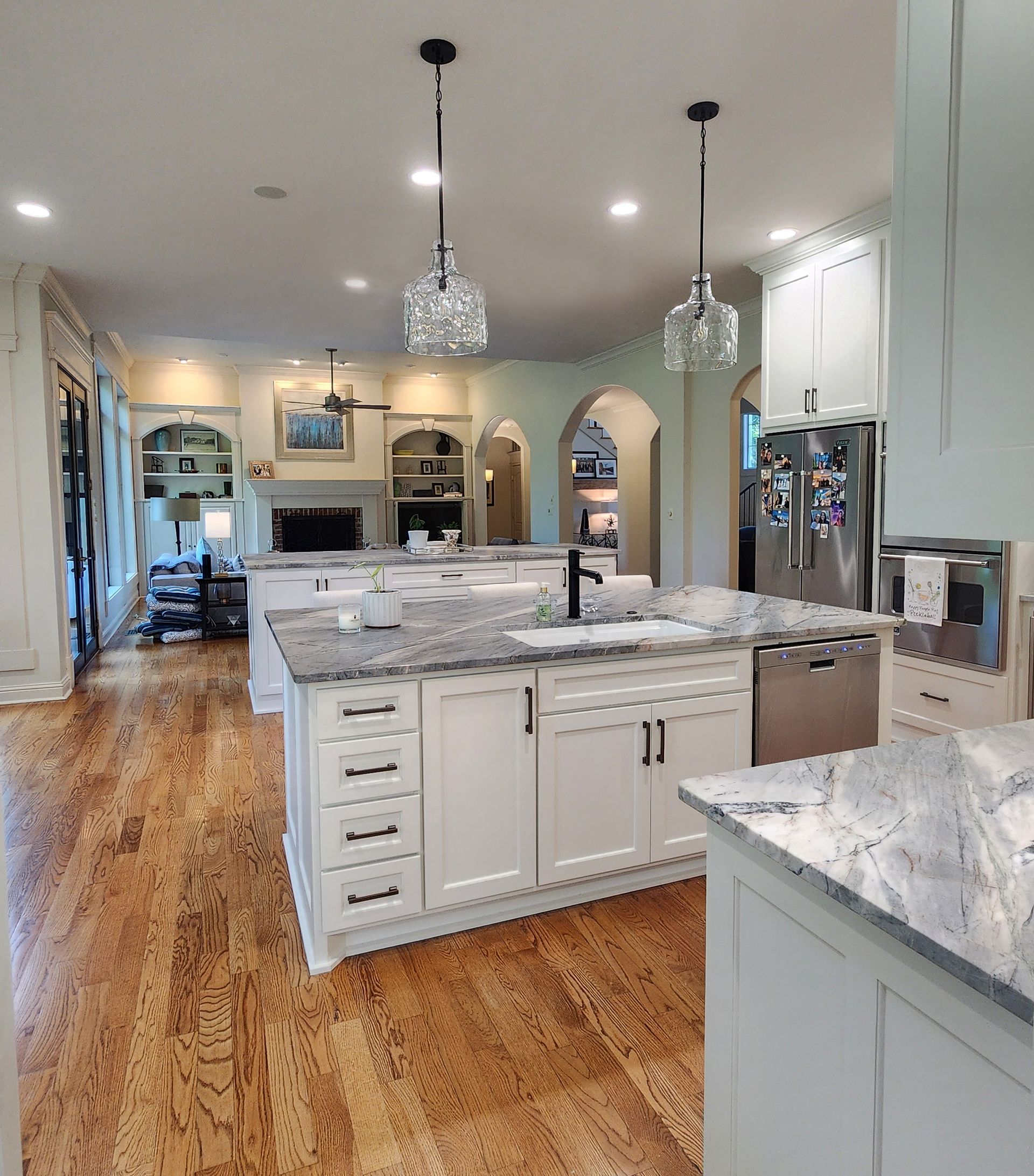 A large kitchen with white cabinets and granite counter tops