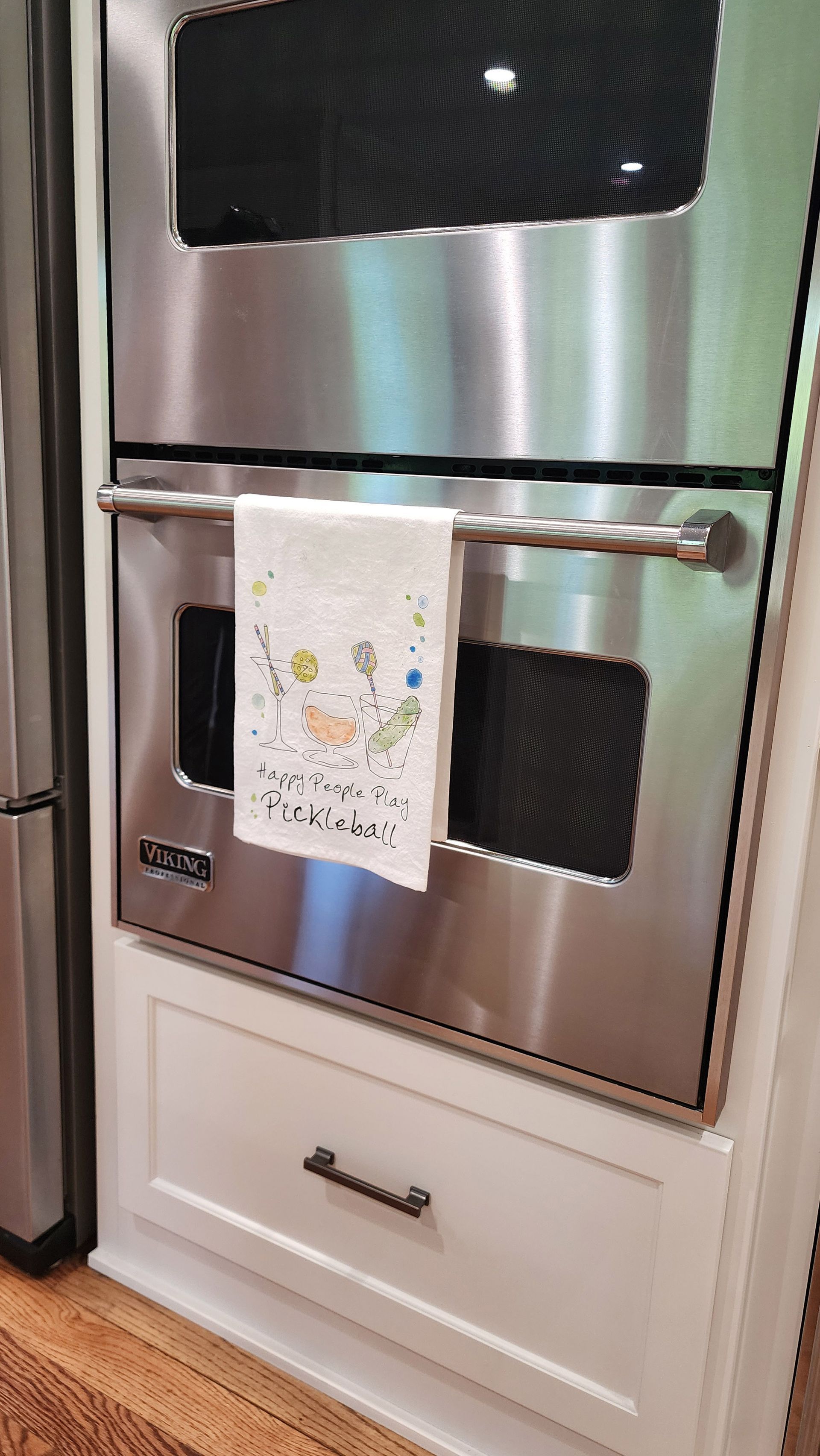 A stainless steel oven with a towel hanging from it.