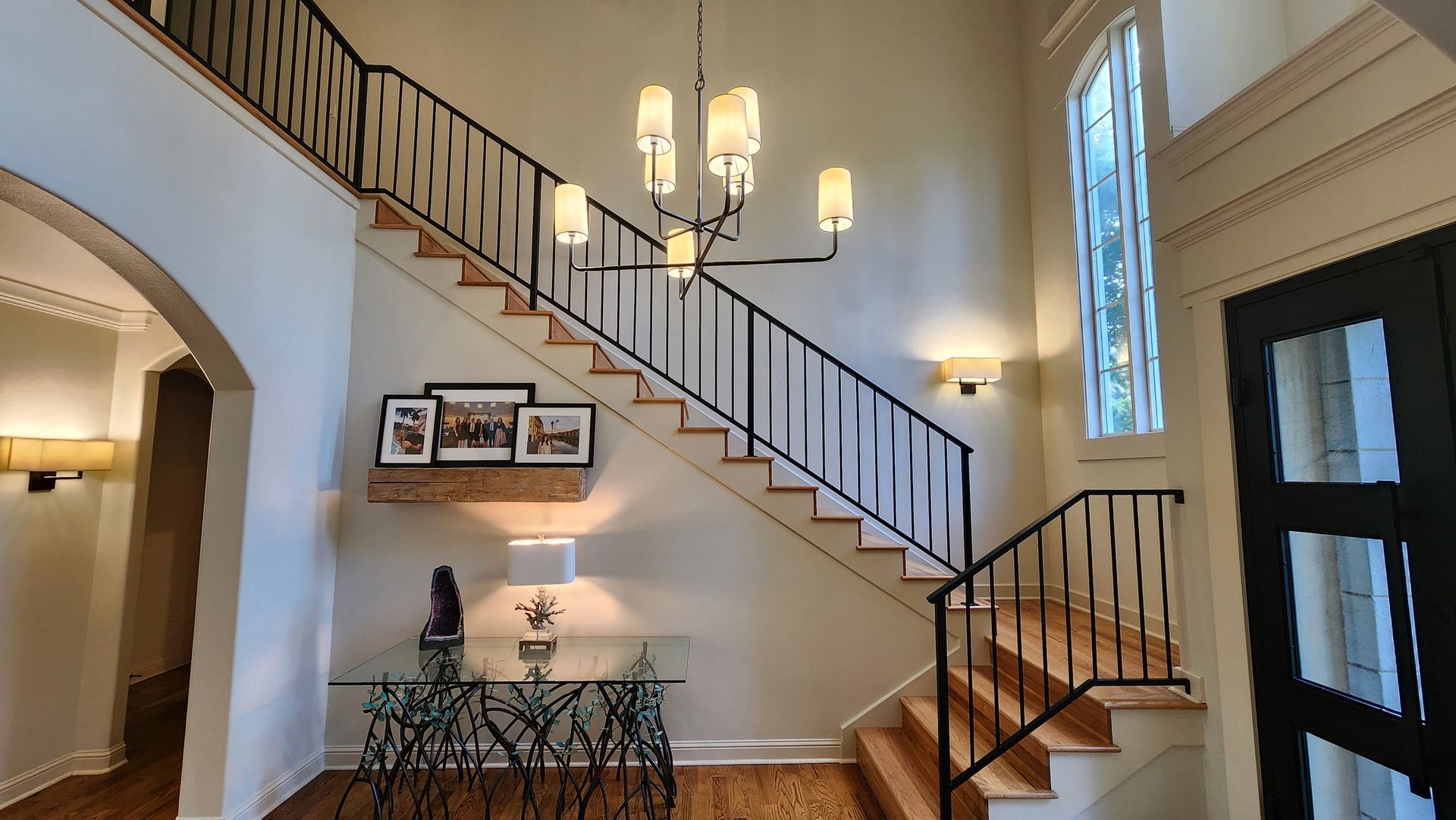 A staircase in a house with a chandelier hanging from the ceiling