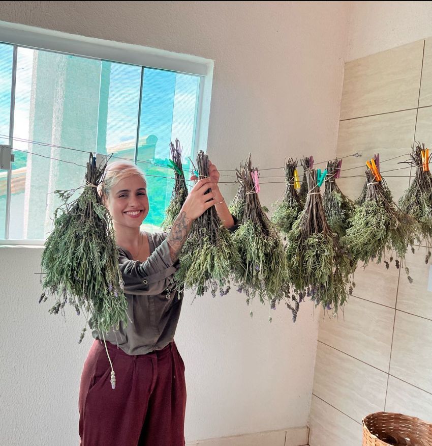 Professora Larissa na Escola das Lavandas, seguando lavandas secas