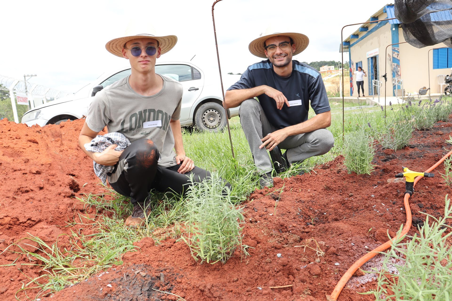 Dois homens, alunos da Escola da Lavanda plantando em um canteiro