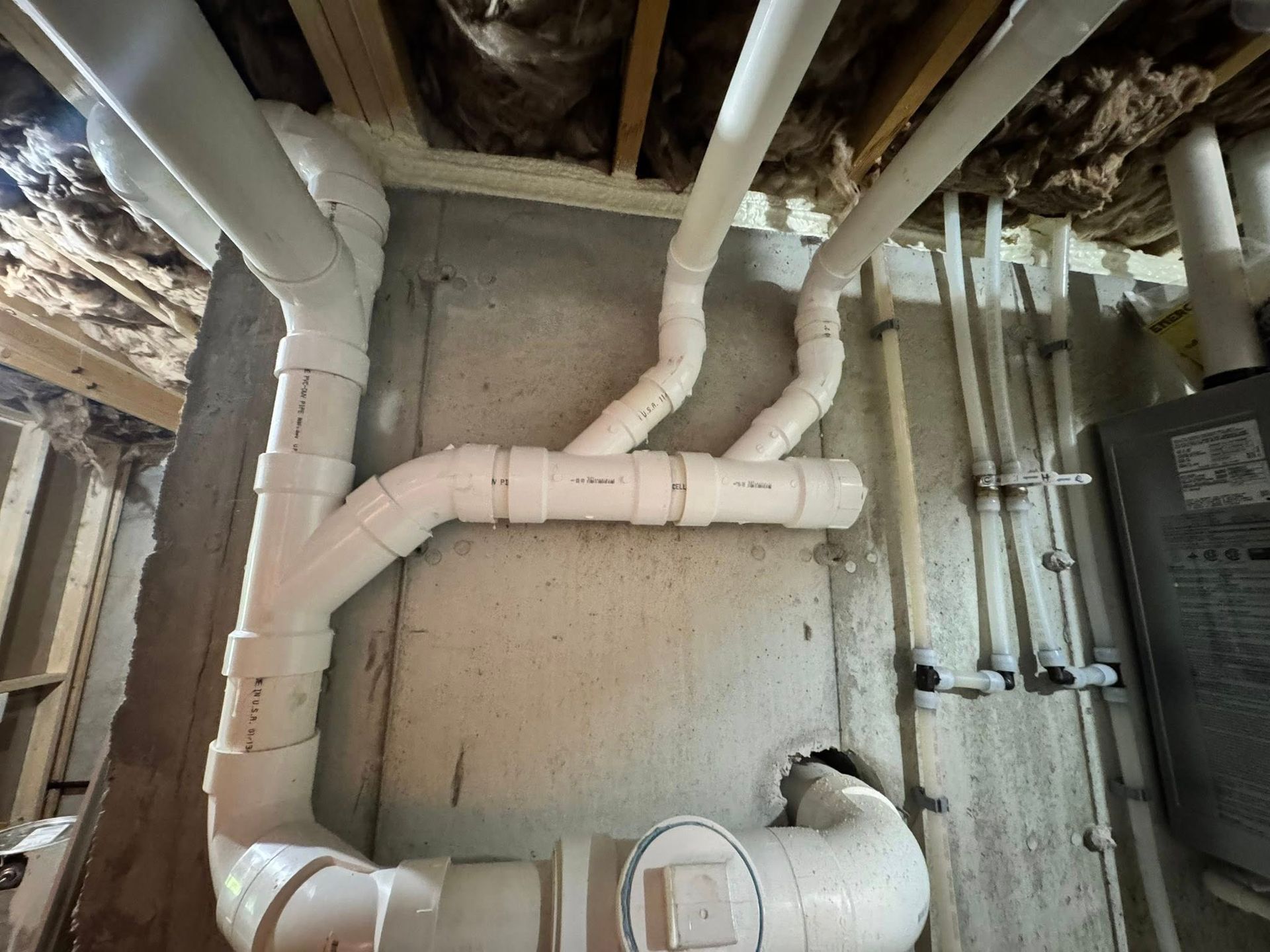 A plumber is fixing a sink pipe with a wrench.
