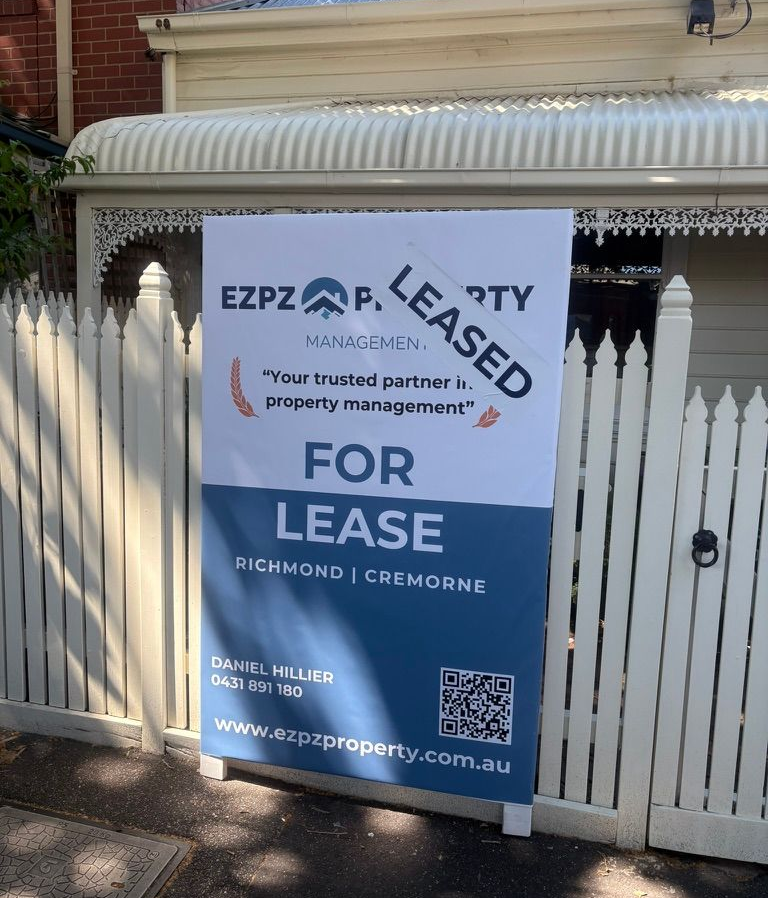  open inspection; white background with text, black and blue trim, QR code, set on asphalt with fallen yellow leaves.