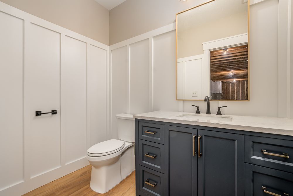 A bathroom with a toilet , sink , and mirror.