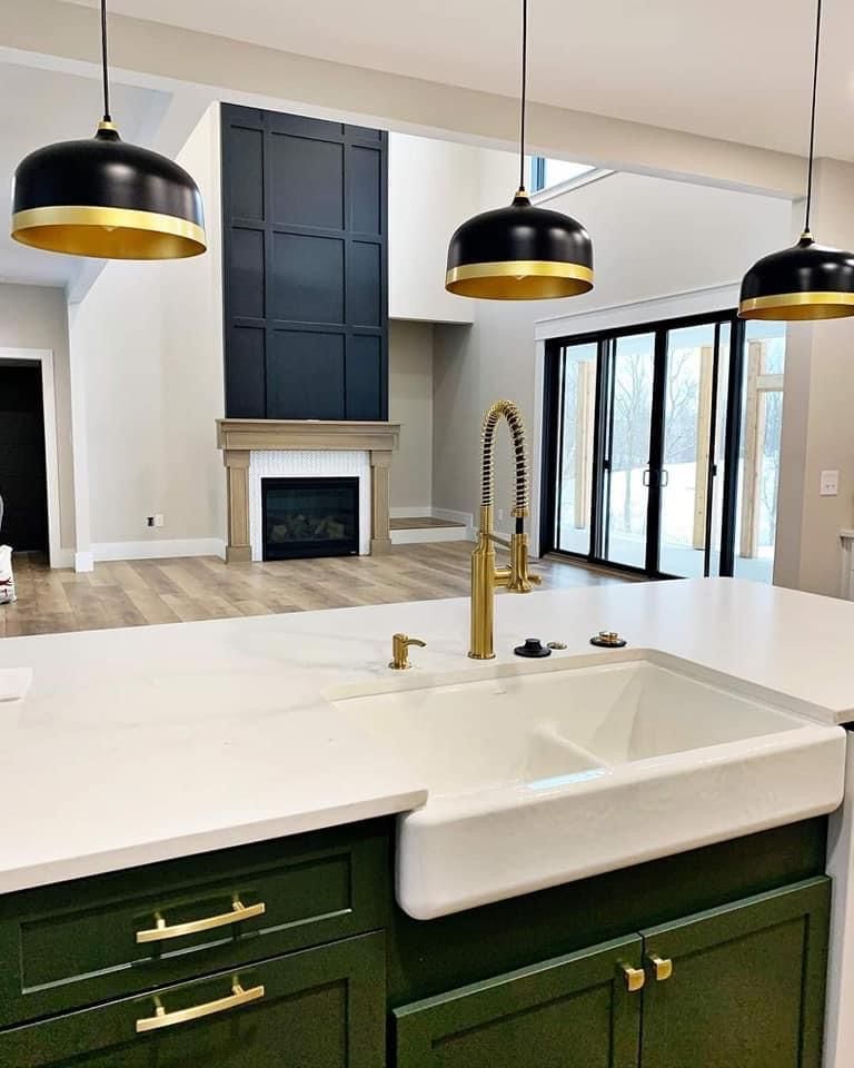 A kitchen with green cabinets and a white sink
