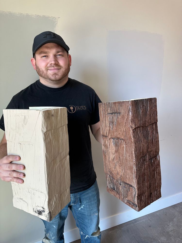 A man is holding two pieces of wood in his hands.