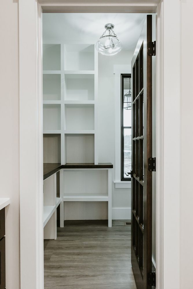 A walk in closet with shelves and a window in a house.