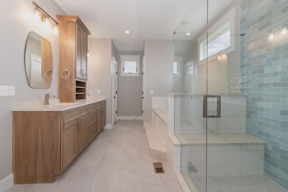 A bathroom with a walk in shower and two sinks.