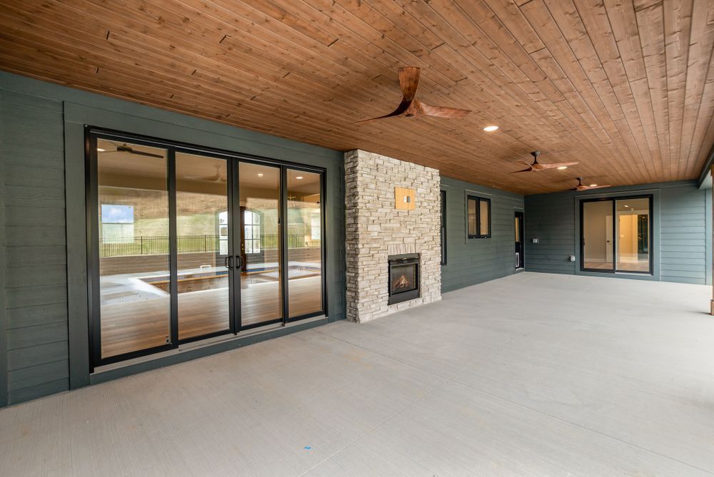 A large patio with a fireplace and sliding glass doors.