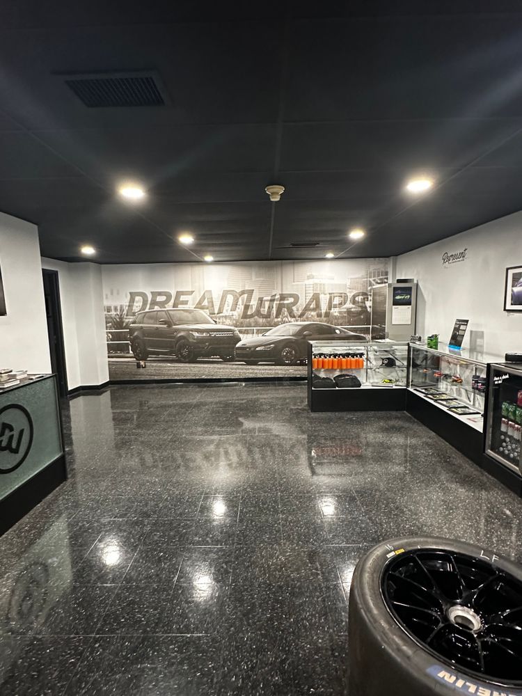 A large room with a picture of a car on the wall.