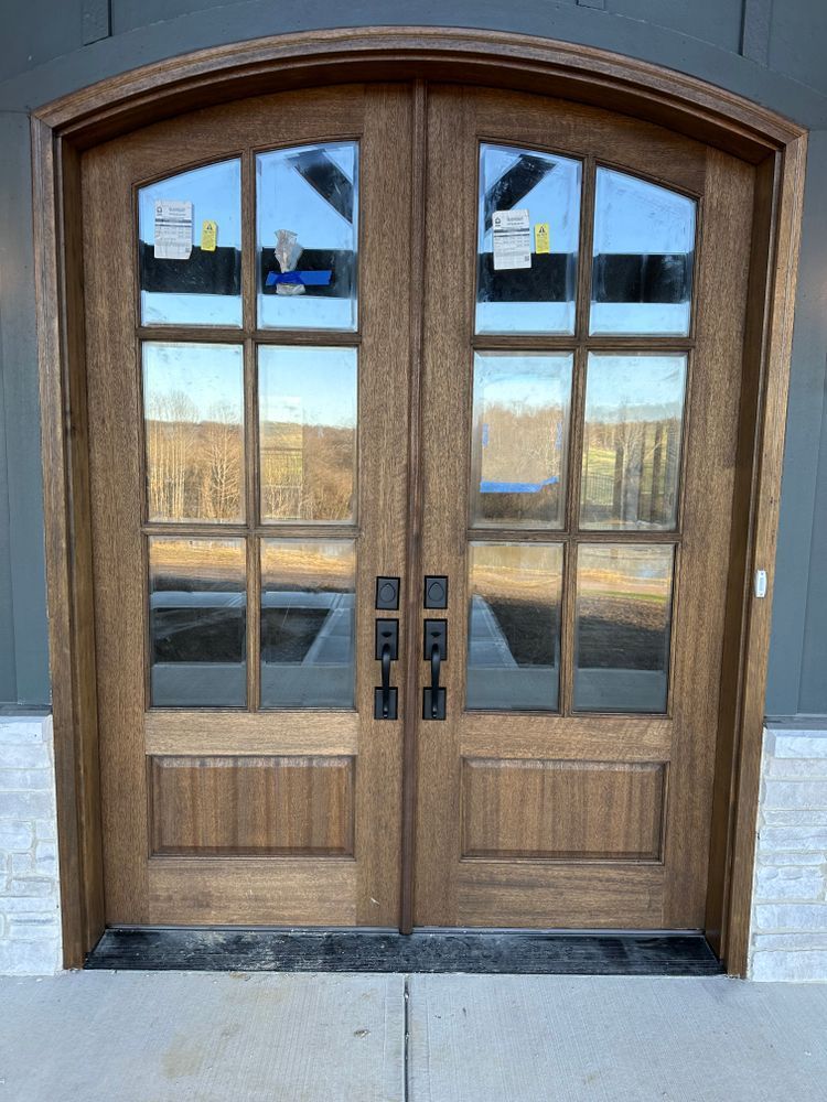 A pair of wooden doors with arched windows