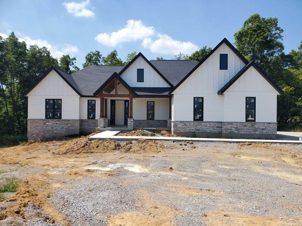 A large white house with a black roof is being built
