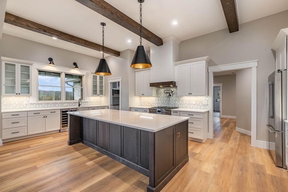 A kitchen with a large island in the middle of it and hardwood floors.