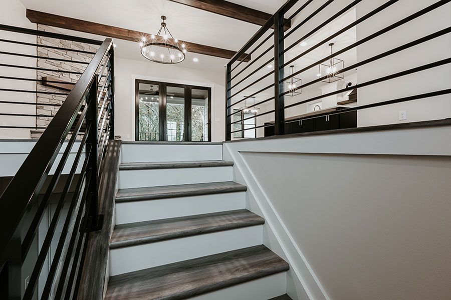 A staircase with wooden steps and a black railing in a house.