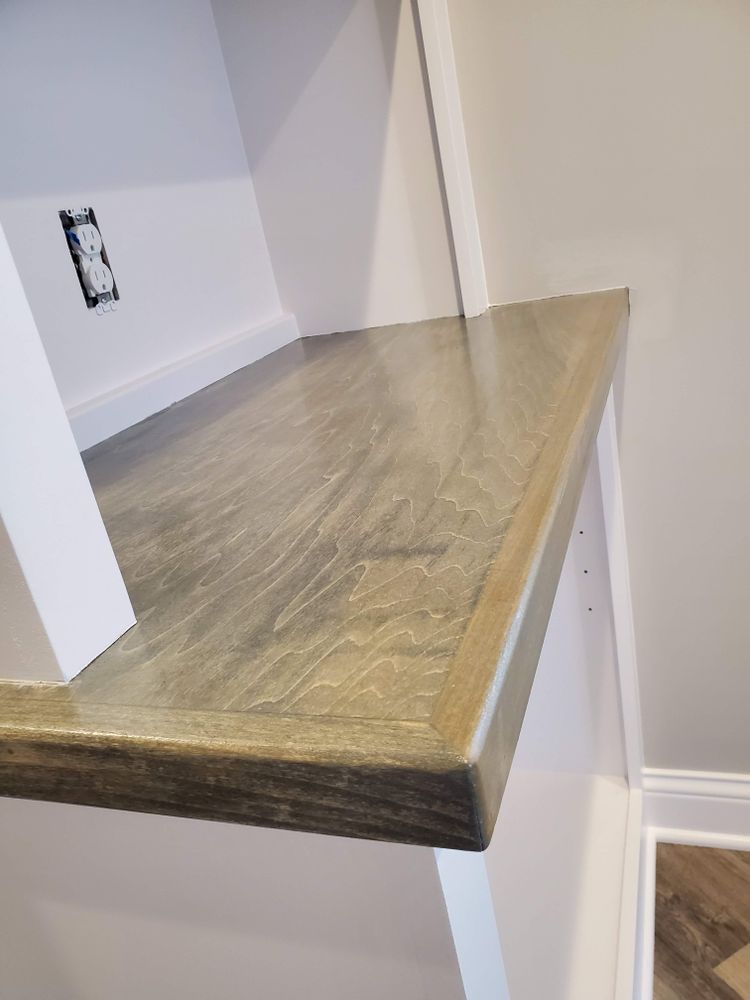 A close up of a wooden shelf in a room.
