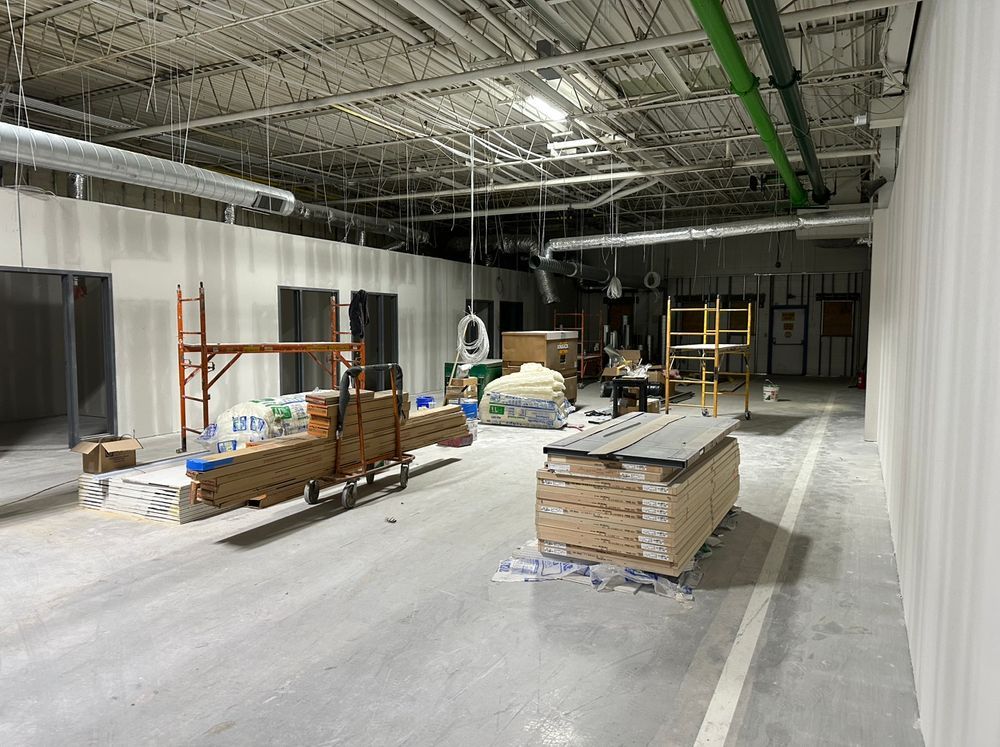 A large empty room with a lot of wood and scaffolding in it.