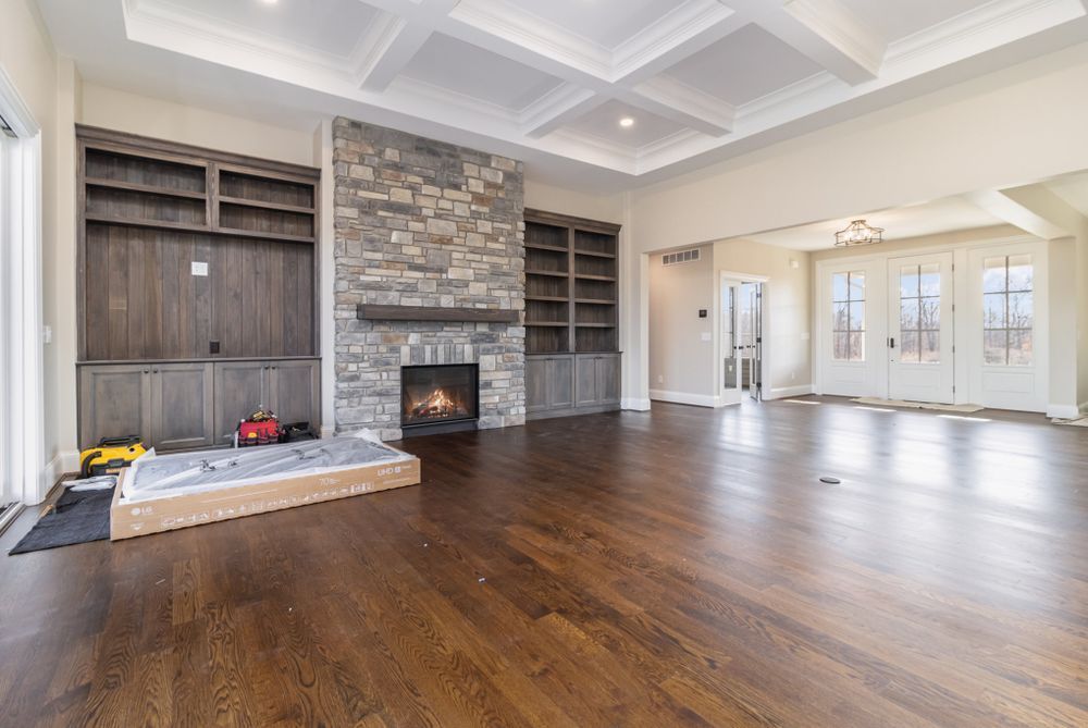 An empty living room with hardwood floors and a fireplace.