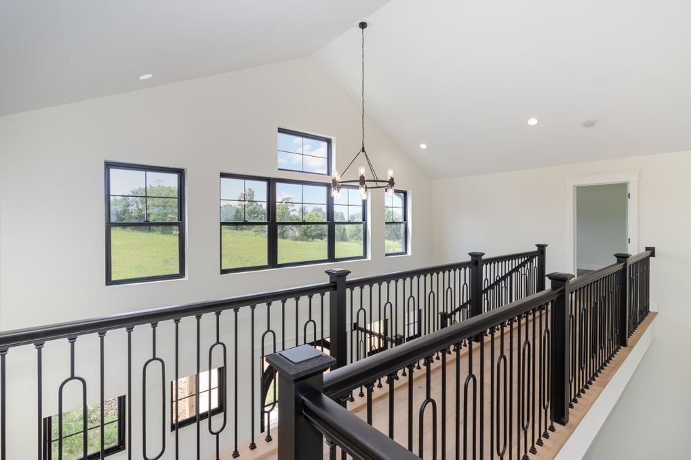 A staircase with a black railing and a chandelier hanging from the ceiling.