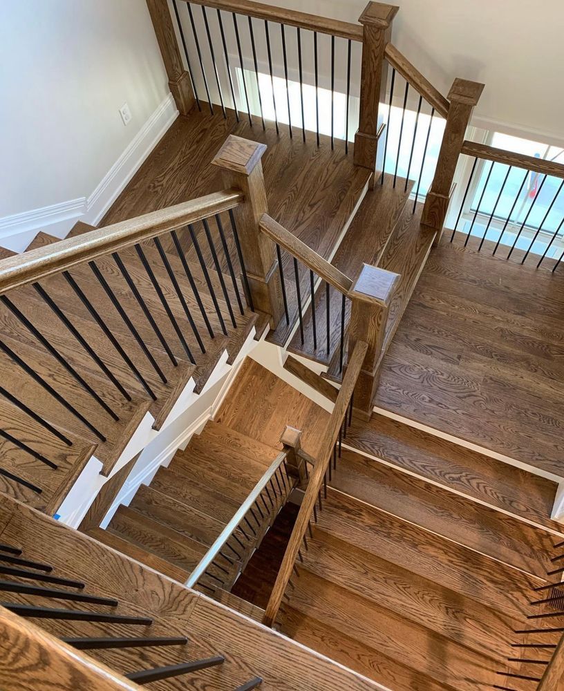 An aerial view of a wooden staircase with a metal railing.