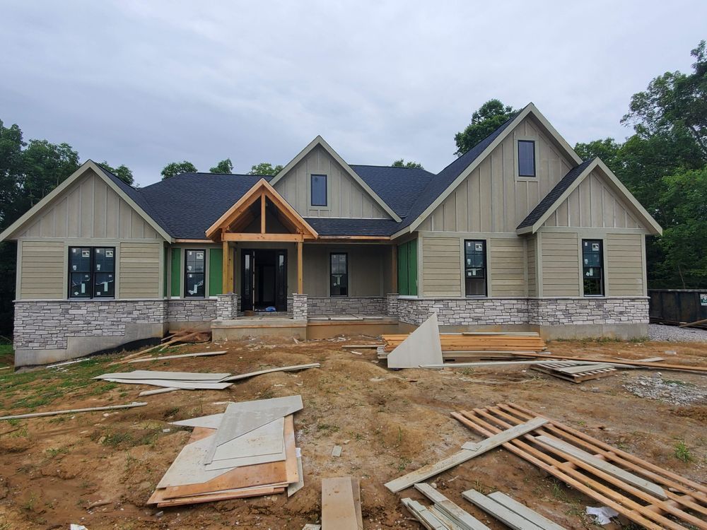 A house under construction with a lot of wood in front of it