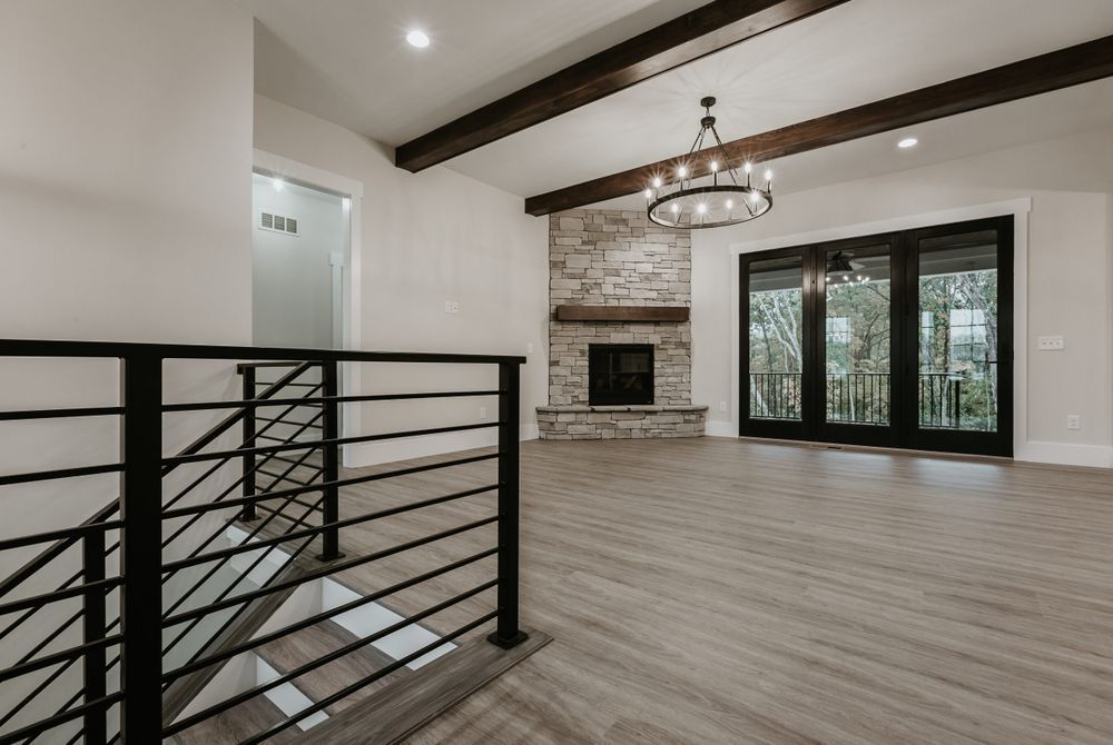 An empty living room with a fireplace and sliding glass doors.