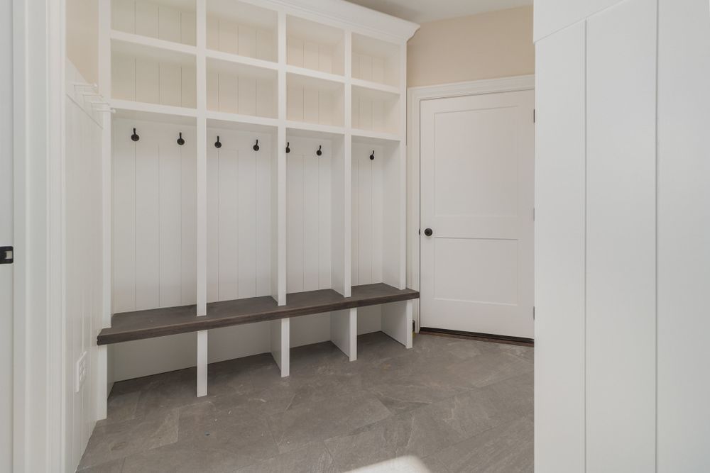A mud room with a bench and hooks on the wall.